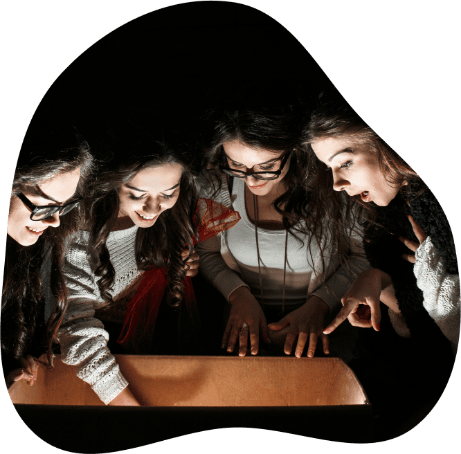 Photo de quatre personnes dans le noir ayant l'air intrigué en regardant dans une boîte lumineuse